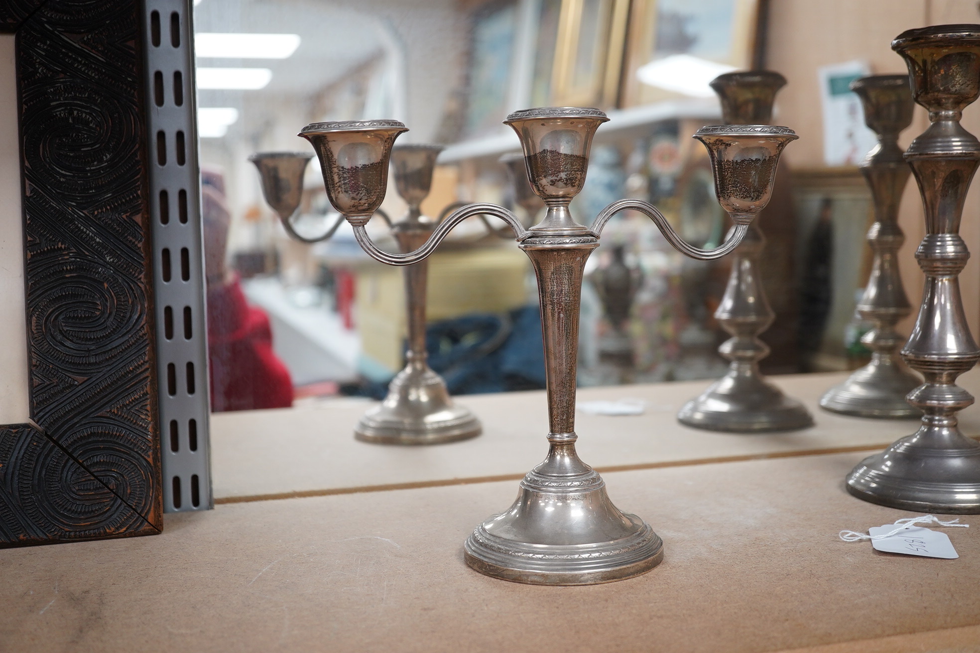 A pair of Elizabeth II silver candlesticks, Broadway & Co, Birmingham, 1960, 25.7cm, weighted, together with a similar silver three light candelabrum, by Adie Bros, weighted. Condition - poor to fair